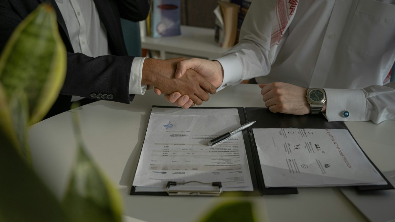 Handshake at desk with papers