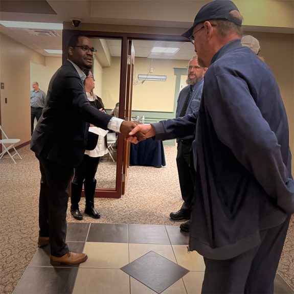 A handshake between an apprentice and an employer partner